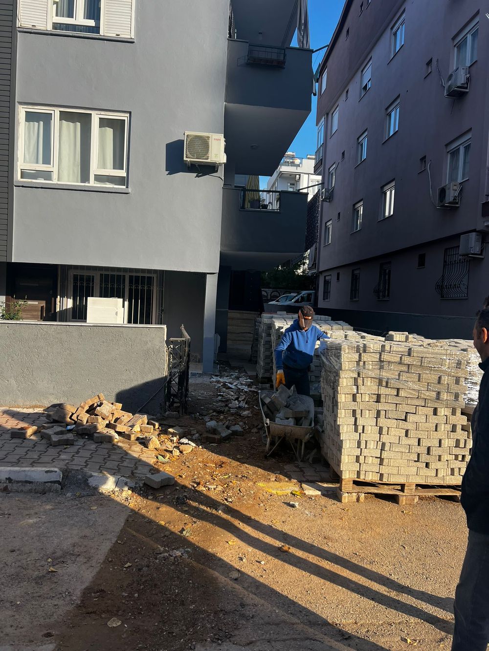 Boyası yenilenen apartmanın önünde parke taşı uygulaması